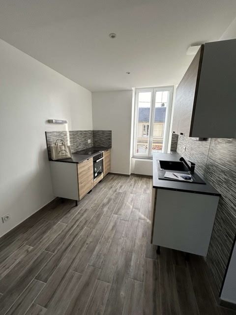 Cuisine équipée livrée par Soly'bat : meubles bois clair, plan de travail noir, sol imitation parquet